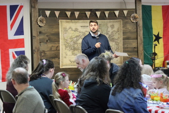 A gathering at Fairview Baptist Temple with a world map and international flags